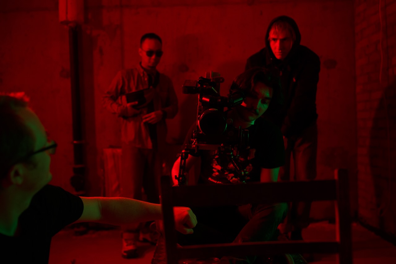 Camera on the set, the director pointing from the edge of frame.