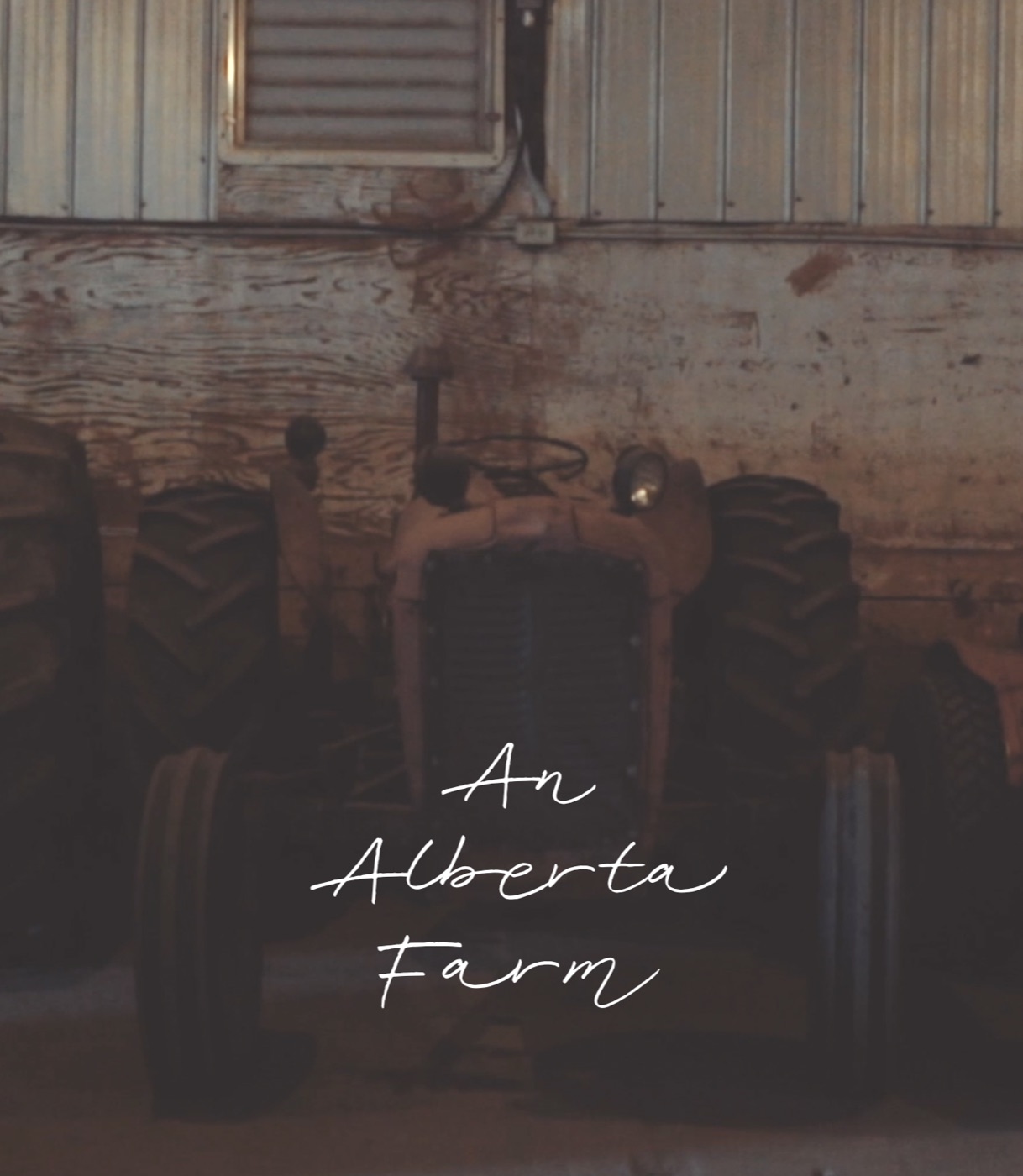 An Alberta Farm poster: a tractor in a dim barn.